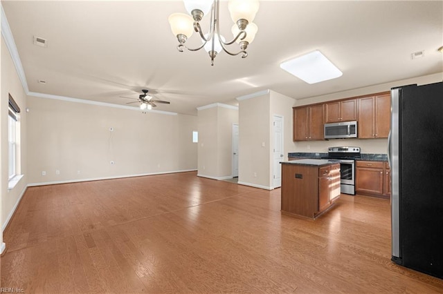 kitchen featuring hanging light fixtures, hardwood / wood-style floors, a center island, and appliances with stainless steel finishes