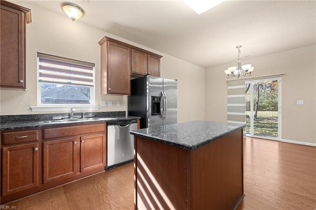 kitchen featuring stainless steel appliances, a center island, sink, and wood-type flooring