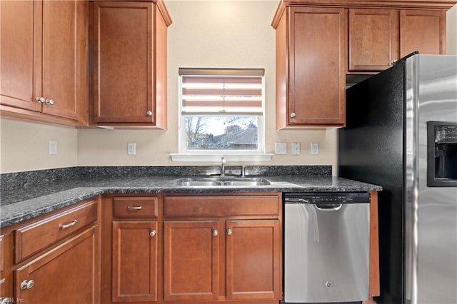 kitchen with dark stone countertops, sink, and appliances with stainless steel finishes