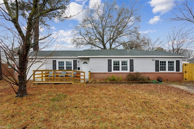 ranch-style home with a wooden deck and a front yard