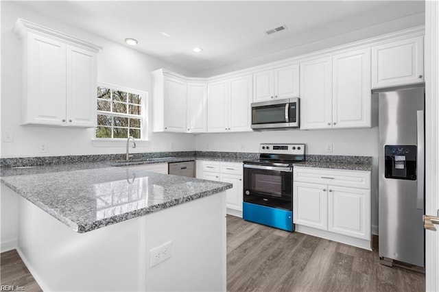 236 Buxton Ave, Newport News, VA 23607 - kitchen featuring sink, appliances with stainless steel finishes, wood-type flooring, white cabinets, and kitchen peninsula