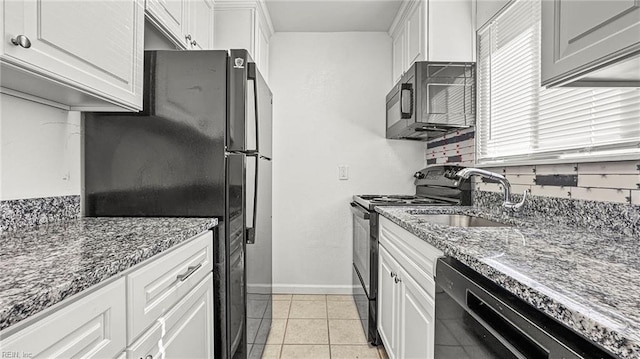 kitchen featuring white cabinets, dark stone countertops, and black appliances