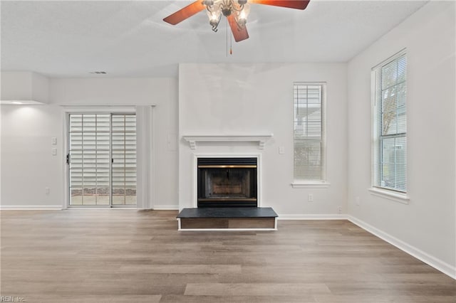 unfurnished living room with wood-type flooring and ceiling fan