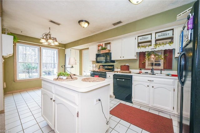 kitchen with sink, black appliances, a kitchen island, pendant lighting, and white cabinets