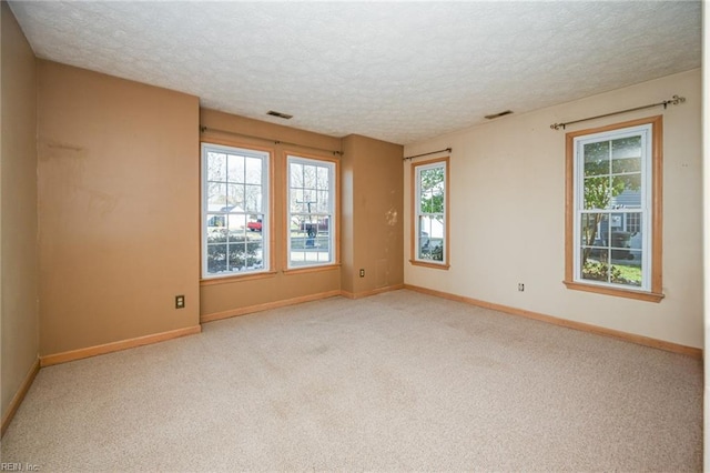 carpeted spare room featuring a textured ceiling