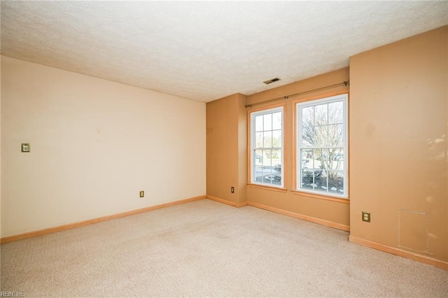 carpeted spare room with a textured ceiling