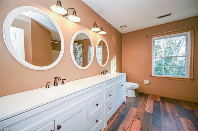 bathroom with hardwood / wood-style flooring, vanity, and toilet