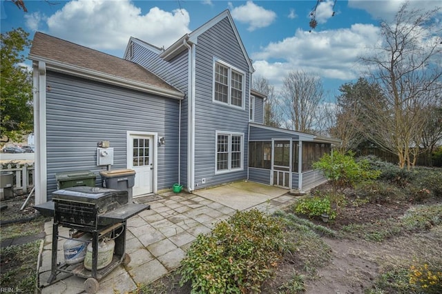 rear view of house with a patio area and a sunroom