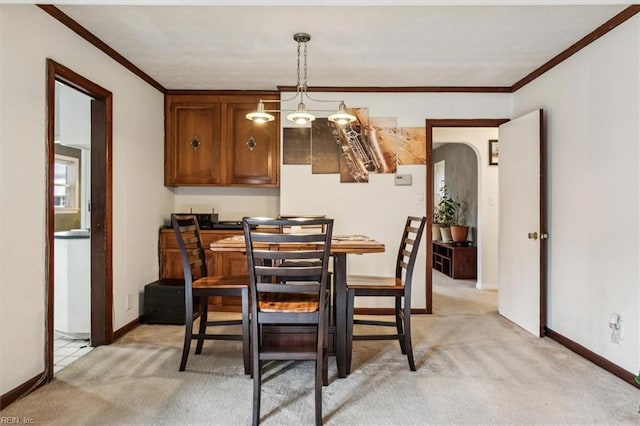 carpeted dining area with ornamental molding