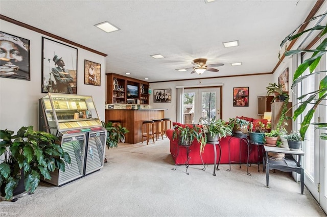miscellaneous room featuring french doors, crown molding, ceiling fan, indoor bar, and light colored carpet
