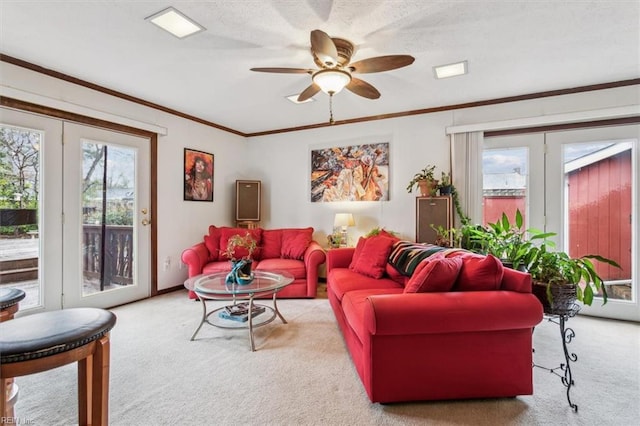 living room featuring crown molding, light colored carpet, and ceiling fan