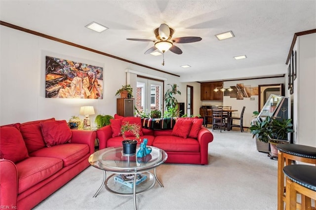 carpeted living room featuring french doors, ceiling fan, ornamental molding, and a textured ceiling