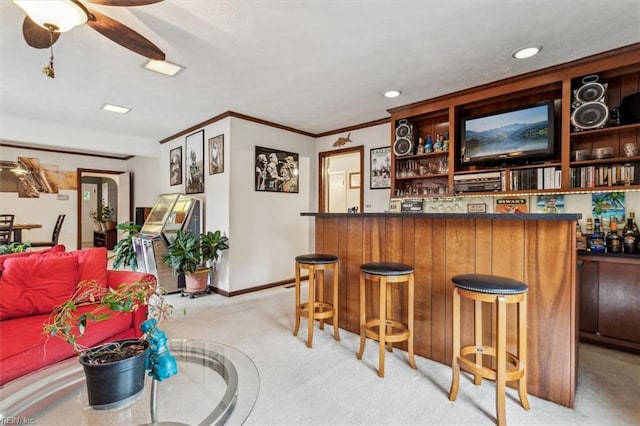 bar featuring ceiling fan, light colored carpet, and ornamental molding