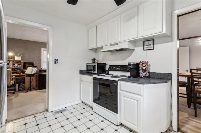 kitchen featuring electric stove and white cabinetry