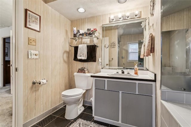 bathroom featuring vanity, a textured ceiling, tile patterned floors, toilet, and a bathing tub