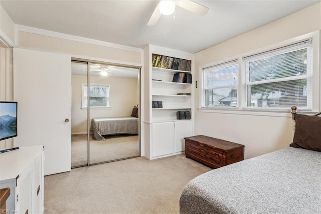 bedroom with light carpet, ceiling fan, and a closet