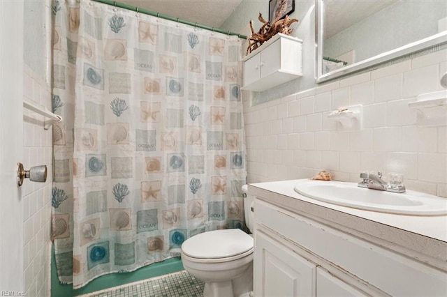 bathroom with tile walls, vanity, curtained shower, and toilet
