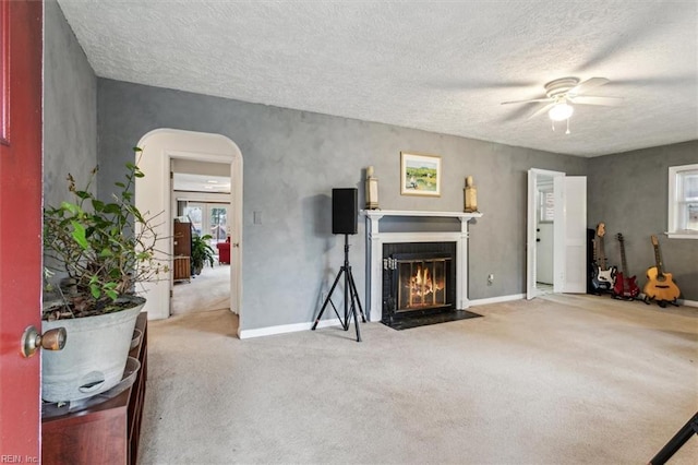 carpeted living room with ceiling fan and a textured ceiling