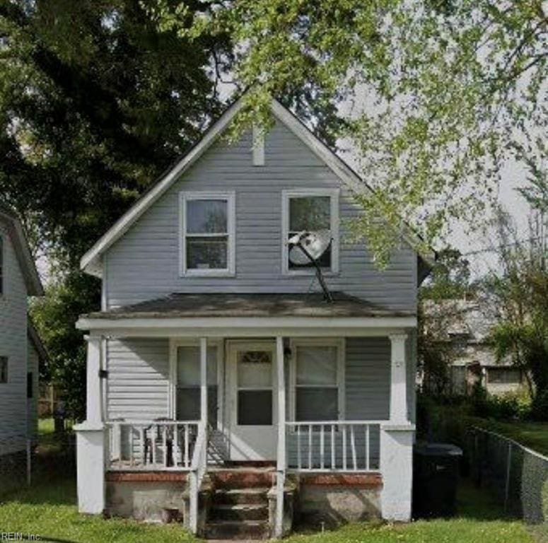 bungalow-style home featuring covered porch and a front lawn