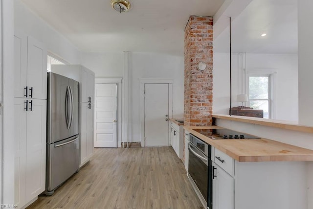 kitchen featuring white cabinetry, wood counters, appliances with stainless steel finishes, and light hardwood / wood-style floors