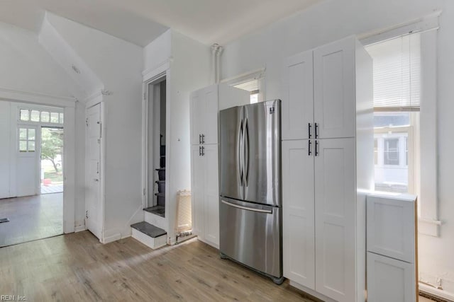 kitchen featuring white cabinetry, stainless steel fridge, and light wood-type flooring