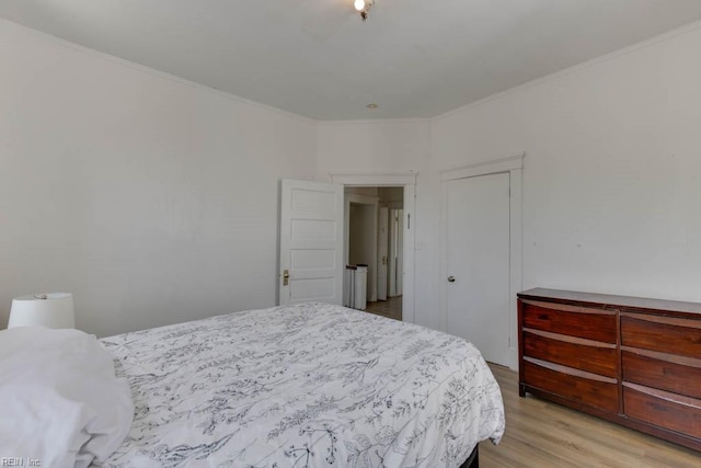 bedroom featuring crown molding and light wood-type flooring