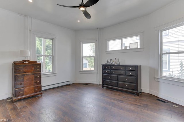 bedroom with multiple windows, a baseboard heating unit, dark wood-type flooring, and ceiling fan