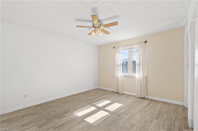 empty room featuring light hardwood / wood-style floors, ceiling fan, and a textured ceiling