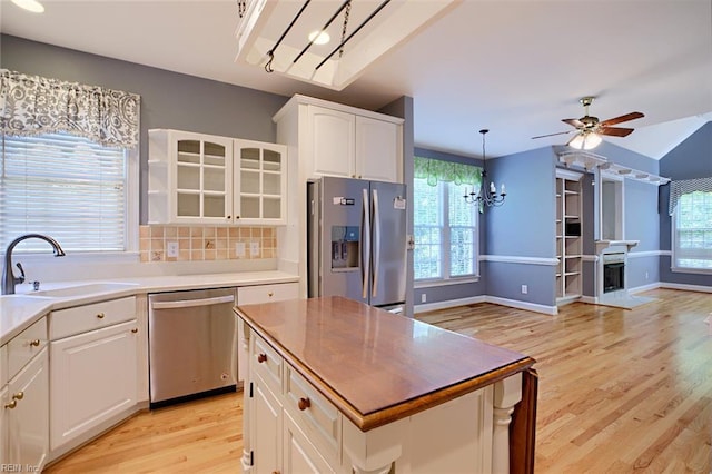 kitchen with sink, white cabinetry, a center island, a wealth of natural light, and stainless steel appliances