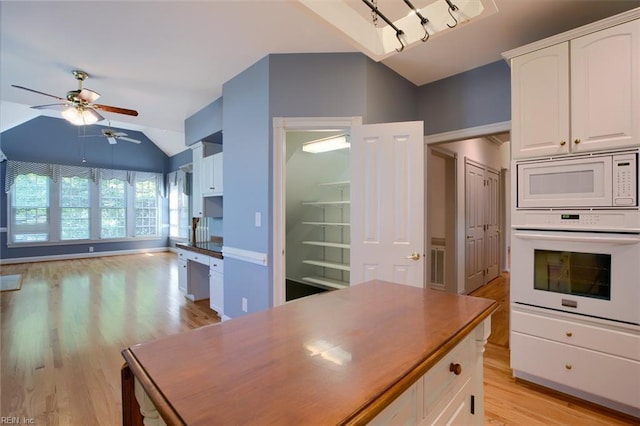 kitchen featuring white cabinetry, lofted ceiling, light wood-type flooring, and white appliances