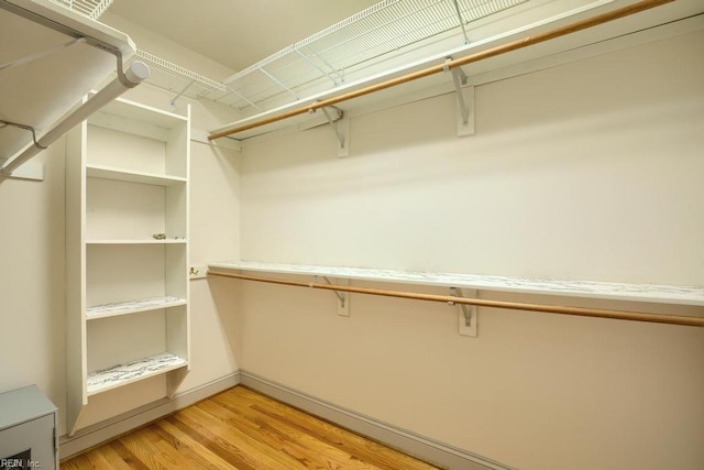 walk in closet with light wood-type flooring