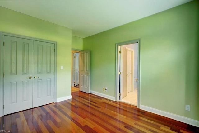 unfurnished bedroom featuring hardwood / wood-style floors and a closet