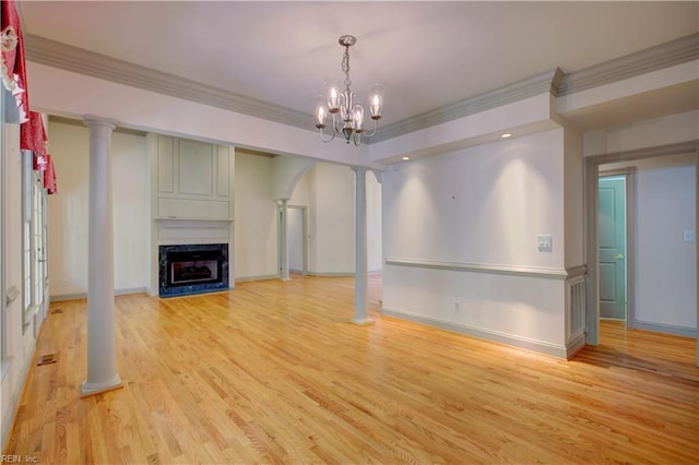 unfurnished living room featuring decorative columns, ornamental molding, a fireplace, and light wood-type flooring