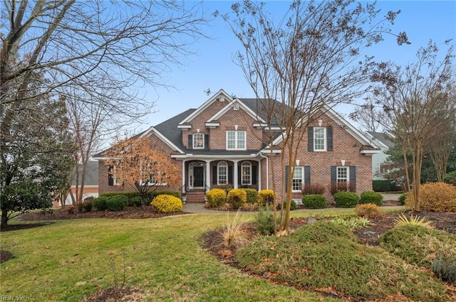 view of front of house featuring brick siding and a front lawn