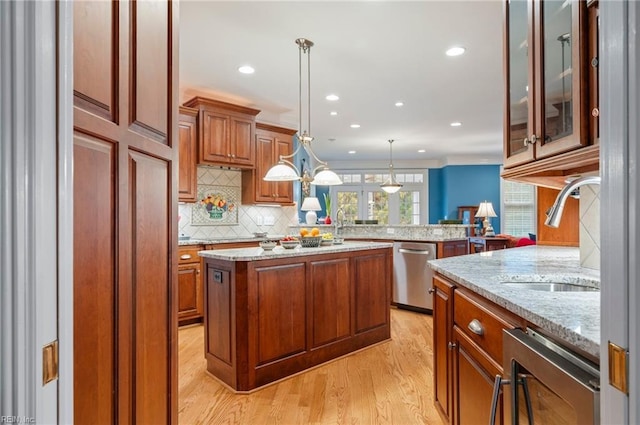 kitchen featuring a peninsula, hanging light fixtures, a center island, dishwasher, and glass insert cabinets