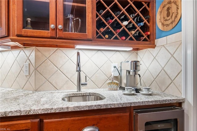 bar with tasteful backsplash, wet bar, beverage cooler, and a sink