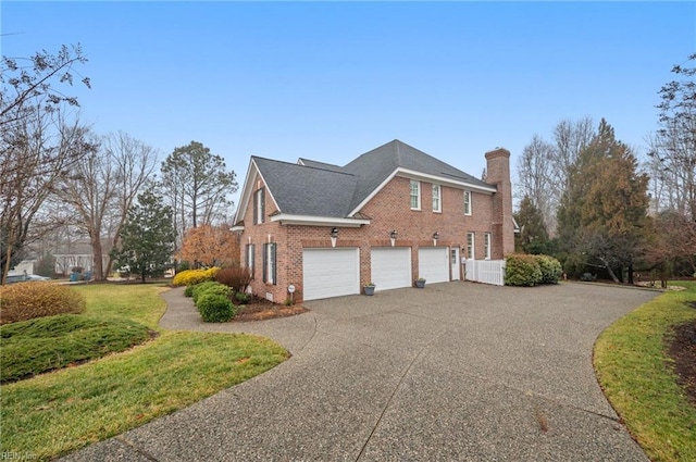 view of property exterior with driveway, a garage, a chimney, and brick siding