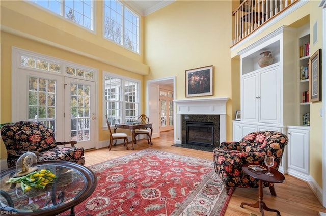 interior space with ornamental molding, a fireplace, light wood-style flooring, and baseboards