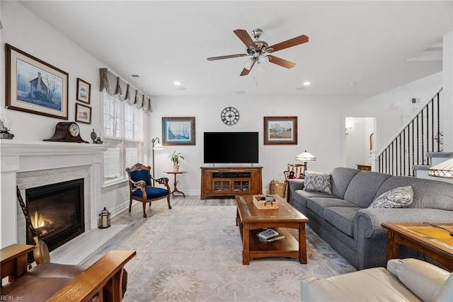 living room with light hardwood / wood-style flooring, a fireplace, and ceiling fan