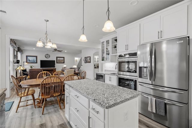 kitchen featuring white cabinetry, appliances with stainless steel finishes, and hanging light fixtures