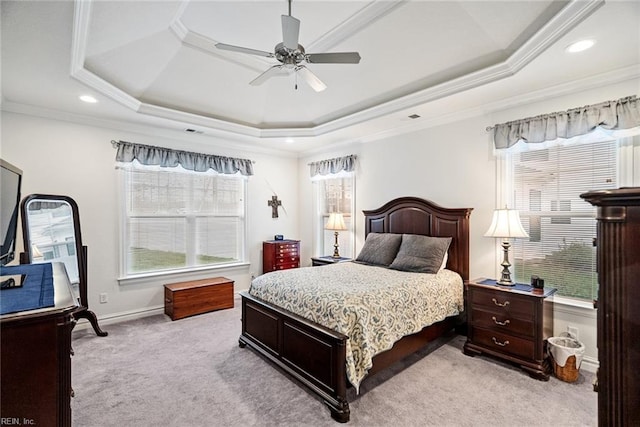 bedroom with a tray ceiling, ornamental molding, light colored carpet, and ceiling fan