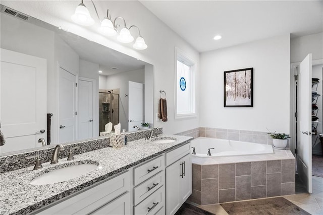 bathroom with shower with separate bathtub and vanity