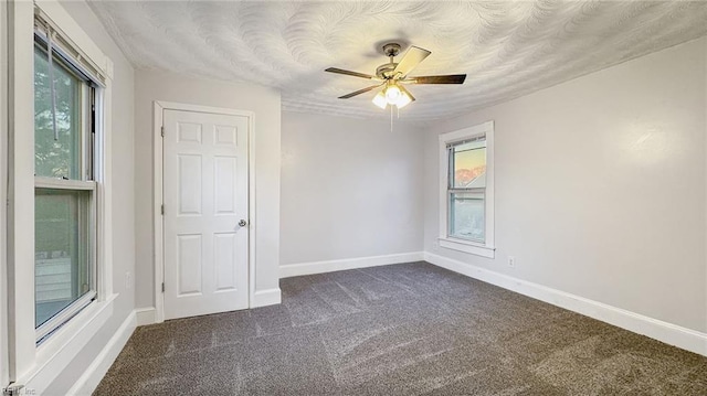 carpeted empty room with a textured ceiling and ceiling fan