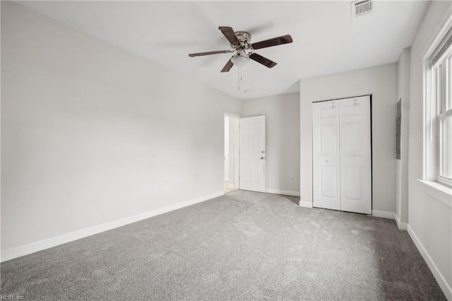 unfurnished bedroom featuring carpet floors, a closet, and ceiling fan