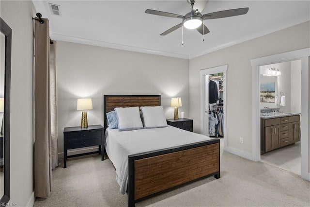 bedroom featuring a walk in closet, ceiling fan, light carpet, ensuite bath, and a closet