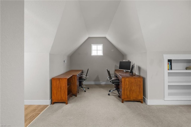 office area featuring vaulted ceiling and light carpet
