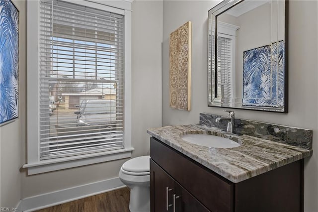 bathroom with hardwood / wood-style flooring, vanity, and toilet