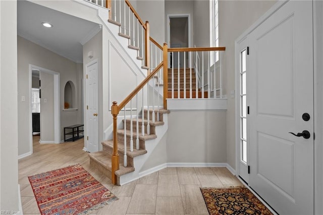 foyer entrance featuring a healthy amount of sunlight and ornamental molding