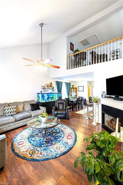 living room with hardwood / wood-style floors, high vaulted ceiling, and ceiling fan