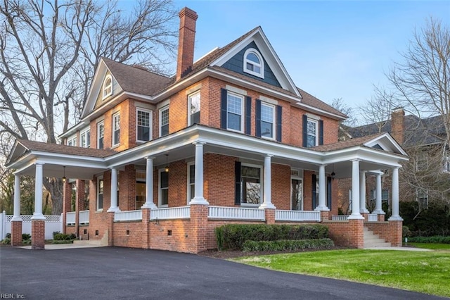 view of front of home with a porch and a front yard